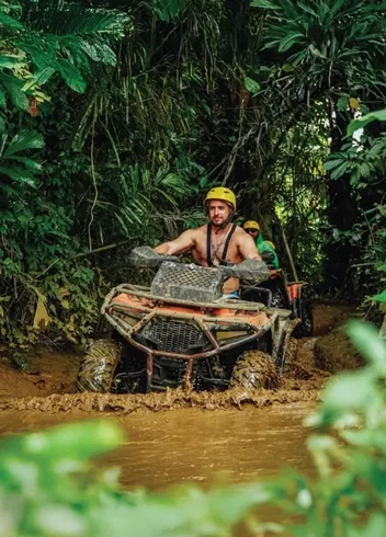 Quad bike through a muddy jungle river